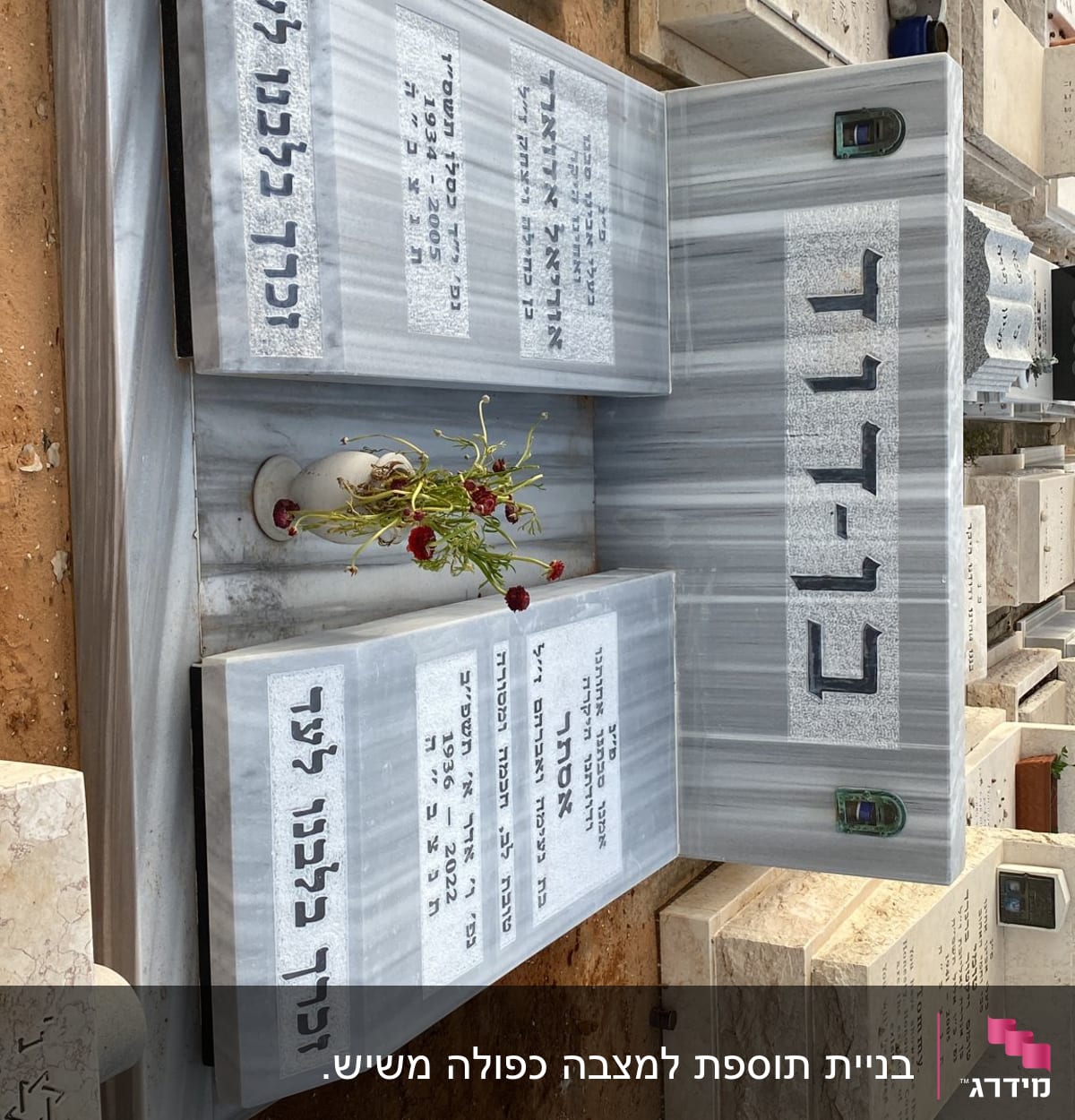 מצבות שיש עם כיתוב בעברית ופרחים באגרטל